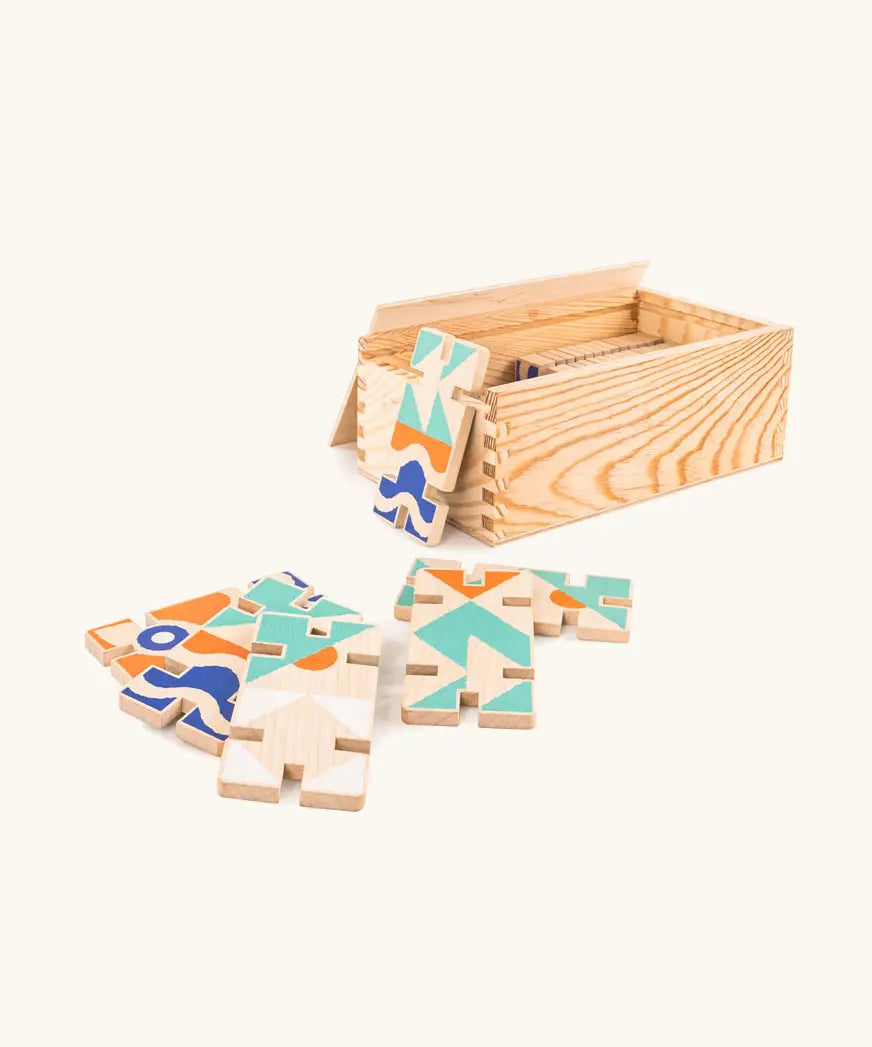 Bajo wooden 3D domino game set showing the pieces with abstract designs next to a wooden storage box