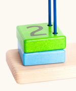 Green wooden block with the number 2 on top from the Bajo count to 5 arched toy