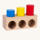 Bajo deep and shallow shape sorter puzzle set available at Babipur. A rectangular shape base with 3 deep cut outs and 3 shallow cut outs. Set includes 3 different coloured wooden tubes in different heights.