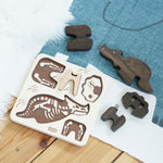 The Bajo Puzzle & Sorter - Black Oak Triceratops and puzzle board laid out on a blue and white rug on a wooden floor