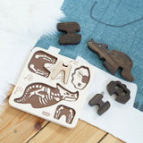 The Bajo Puzzle & Sorter - Black Oak Triceratops and puzzle board laid out on a blue and white rug on a wooden floor