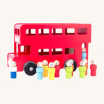 A the wooden peg doll passengers and drivers are outside the red London bus, on a cream background