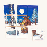 A winter scene of the Bajo Double Sided Puzzle Blocks, showing the Gruffalo with a baby Gruffalo, a snowy woodland, a navy blue sky and a full moon