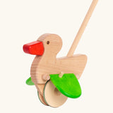 Unpainted wooden duck with a red beak, green wings and wheels on the Bajo push along toy
