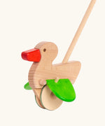 Unpainted wooden duck with a red beak, green wings and wheels on the Bajo push along toy