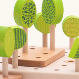 Wooden green trees standing inside the holes on the board from the Bajo central park forest set