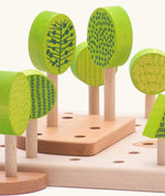 Wooden green trees standing inside the holes on the board from the Bajo central park forest set