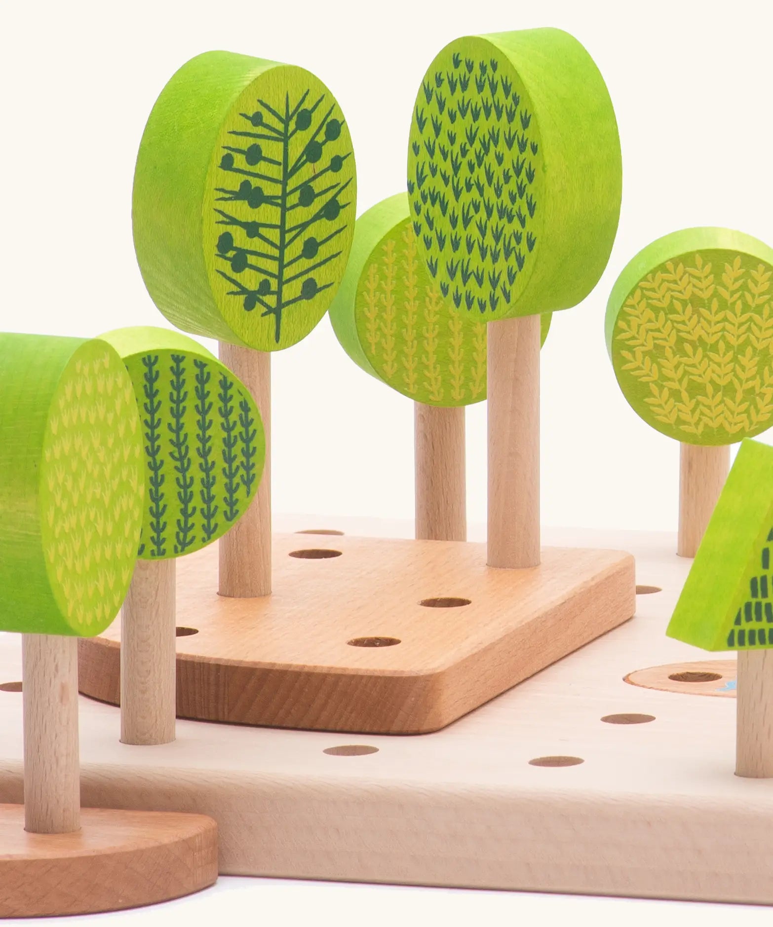 Wooden green trees standing inside the holes on the board from the Bajo central park forest set