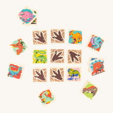 The Bajo Dinosaur Memory Game Toy showing square pieces with dinosaur pictures and dinosaur feet in a row of 3 by 3, with scattered dinosaur blocks surrounding the rows. 