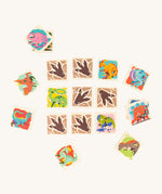 The Bajo Dinosaur Memory Game Toy showing square pieces with dinosaur pictures and dinosaur feet in a row of 3 by 3, with scattered dinosaur blocks surrounding the rows. 