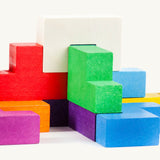 Different coloured wooden blocks from the Bajo Pentomino puzzle set stacked on top of each other