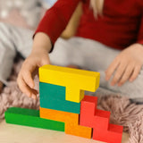 A child building using different Bajo wooden coloured Pentomino puzzle blocks