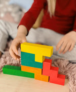A child building using different Bajo wooden coloured Pentomino puzzle blocks