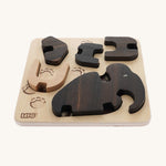 The Bajo Puzzle & Sorter - Black Oak Mammoth, showing the wooden mammoth pieces inside the wooden puzzle board on a cream background
