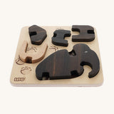The Bajo Puzzle & Sorter - Black Oak Mammoth, showing the wooden mammoth pieces inside the wooden puzzle board on a cream background