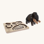 Bajo Puzzle & Sorter - Black Oak Mammoth which has been built and is stood next to it wooden puzzle tray, on a cream background