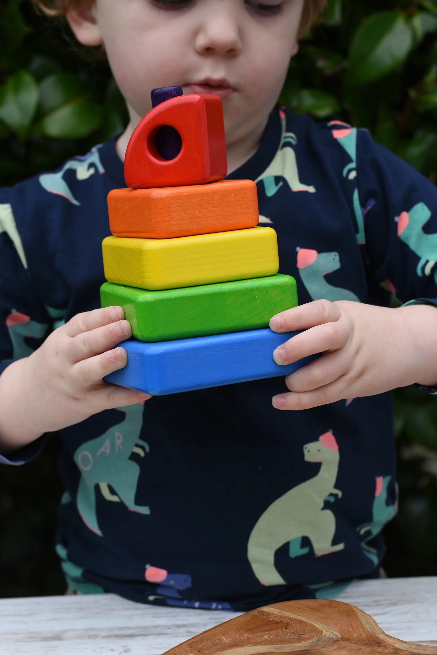 Child holding the Bajo Puzzle Stacker Tower in his hands.