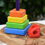 Bajo Puzzle Stacker Tower on a wooden base piece with the top red pieces placed besides it.