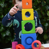 Child stacking the pieces from the Bajo Puzzle Stacker Tower on top of each other.