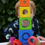 Child peering through stacked blocks from the Bajo Puzzle Stacker Tower.