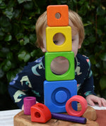 Child peering through stacked blocks from the Bajo Puzzle Stacker Tower.