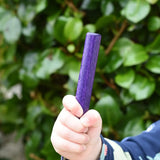 Child holding the purple pole from the Bajo Puzzle Stacker Tower in his hand. 