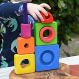 Child stacking the pieces from the Bajo Puzzle Stacker Tower on top of each other.