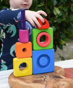 Child stacking the pieces from the Bajo Puzzle Stacker Tower on top of each other.