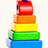 Bajo tower stacker puzzle set showing 5 wooden coloured blocks threaded through a purple pin
