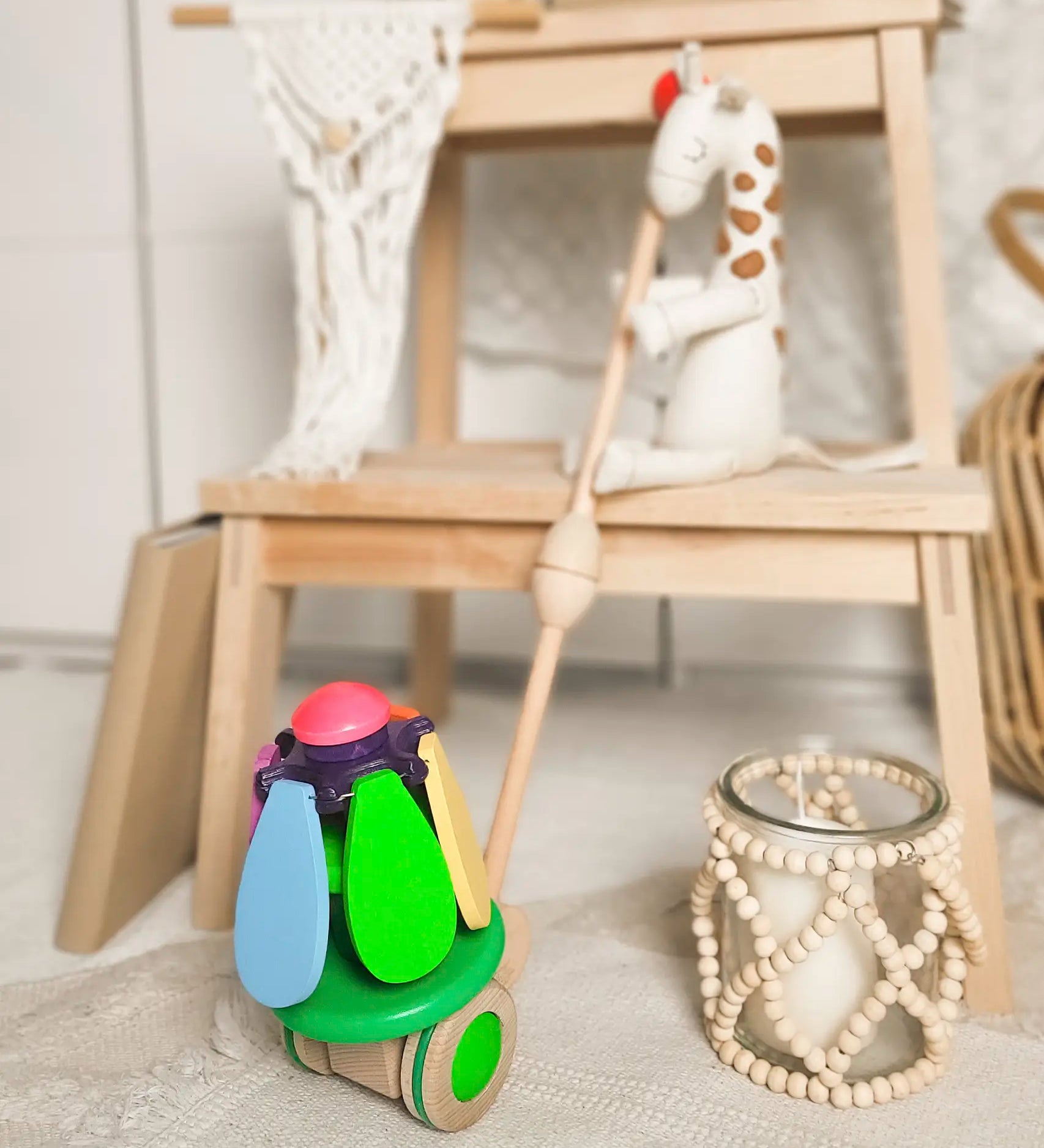 Bajo wooden rainbow flower push along toy leaning on display table 
