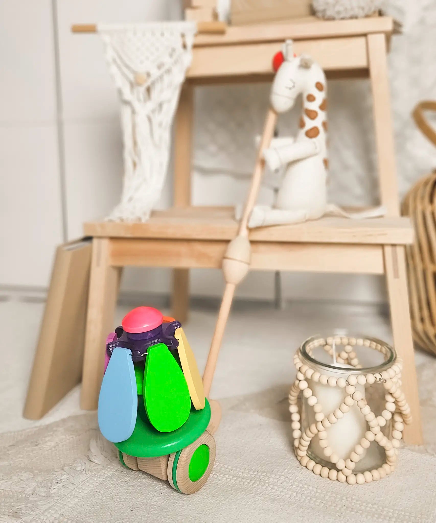 Bajo wooden rainbow flower push along toy leaning on display table 