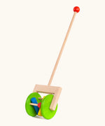 Bajo rattle push along toy showing 2 large green wooden wheels, long handle and 3 coloured cylinder rattles