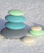 Set of 10 smooth, tactile wooden circular pebbles by Bajo in shades of blue and white, for stacking or small world play, available at Babipur.