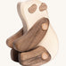 The Tobe Wooden Panda baby toy is sitting down on its back legs. It is a beautifully crated panda in two tone wood, with a white body, dark brown arms and legs, dark brown ears and eye patches. This wonderful wooden toy has movable arms and legs, and is on a cream background