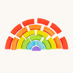 Bajo plastic-free stacking wooden rainbow blocks laid out on a cream background