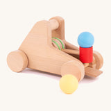A Bajo wooden catapult toy set available available at Babipur. Set includes 2 wooden balls with a pull back catapult system with wheels