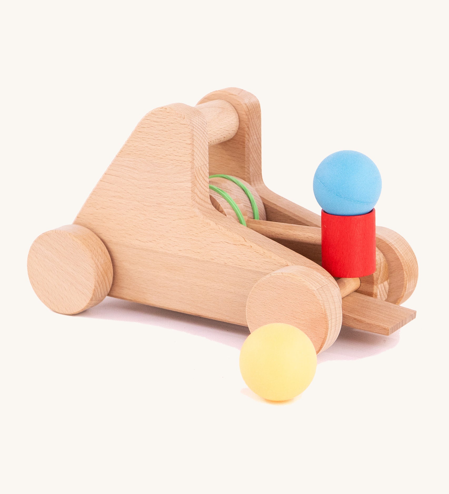 A Bajo wooden catapult toy set available available at Babipur. Set includes 2 wooden balls with a pull back catapult system with wheels