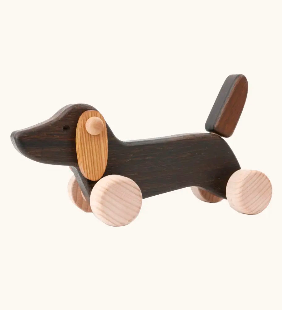 Bajo Dachshund Brown Puppy Push along toy, made from wood, on 4 wheels with floppy ears and a pointed tail.