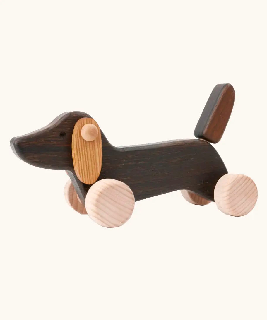 Bajo Dachshund Brown Puppy Push along toy, made from wood, on 4 wheels with floppy ears and a pointed tail.