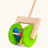 Large green wooden wheels with cylinder rattles on the Bajo rattle push along toy