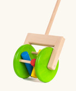 Large green wooden wheels with cylinder rattles on the Bajo rattle push along toy