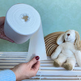 Hand holding a roll of Disposable Paper Nappy Liners for reusable nappies by Bambinex, available to buy at Babipur.