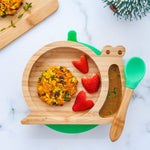 Eco Rascals Snail Bamboo Suction Plate with green suction base, filled with a vegetable patty, strawberry hearts, and a side dip,  and a green silicone and bamboo baby spoon.