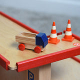A mini wooden toy delivery lorry on top of the wooden toy multi-story car park by Beck-Holzspielzeug