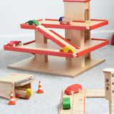 The multi-storey car park wooden toy by Beck-Holzspielzeug, with mini wooden toy cars, and surrounded by the Beck wooden road set and parking garage.