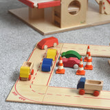 The wooden road and city system playset by Beck-Holzspielzeug, set up in a small-world town play scene with toy cars and traffic cones. 