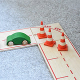 The mini wooden toy traffic cones by Beck Holzspielzeug, placed on the wooden toy road for small-world play