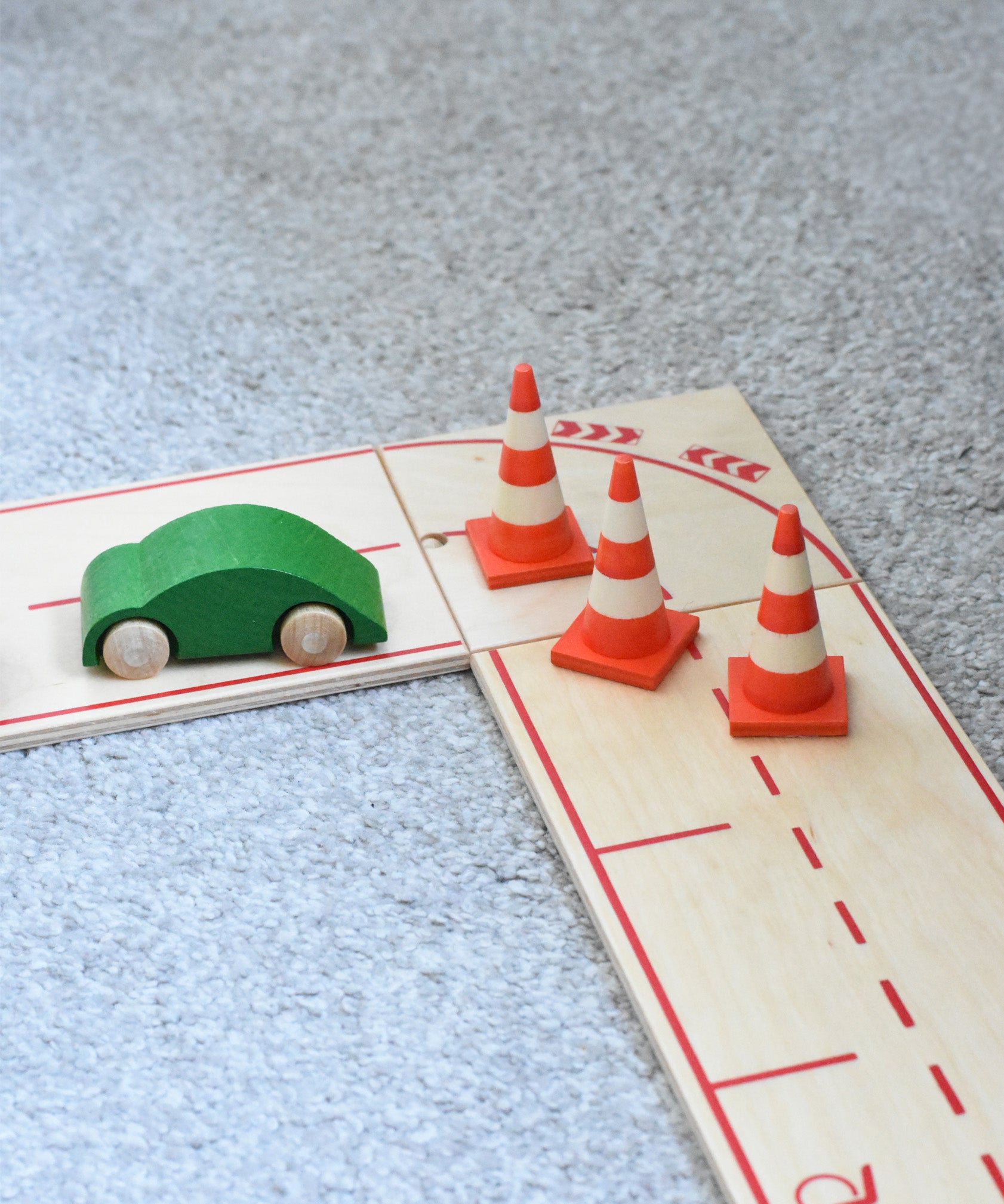 The mini wooden toy traffic cones by Beck Holzspielzeug, placed on the wooden toy road for small-world play