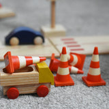 A mini wooden toy delivery lorry by Beck-Holzspielzeug, carrying wooden toy traffic cones.