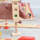The wooden mini traffic light toy by Beck-Holzspielzeug, being switched to a green light for small world city play. 